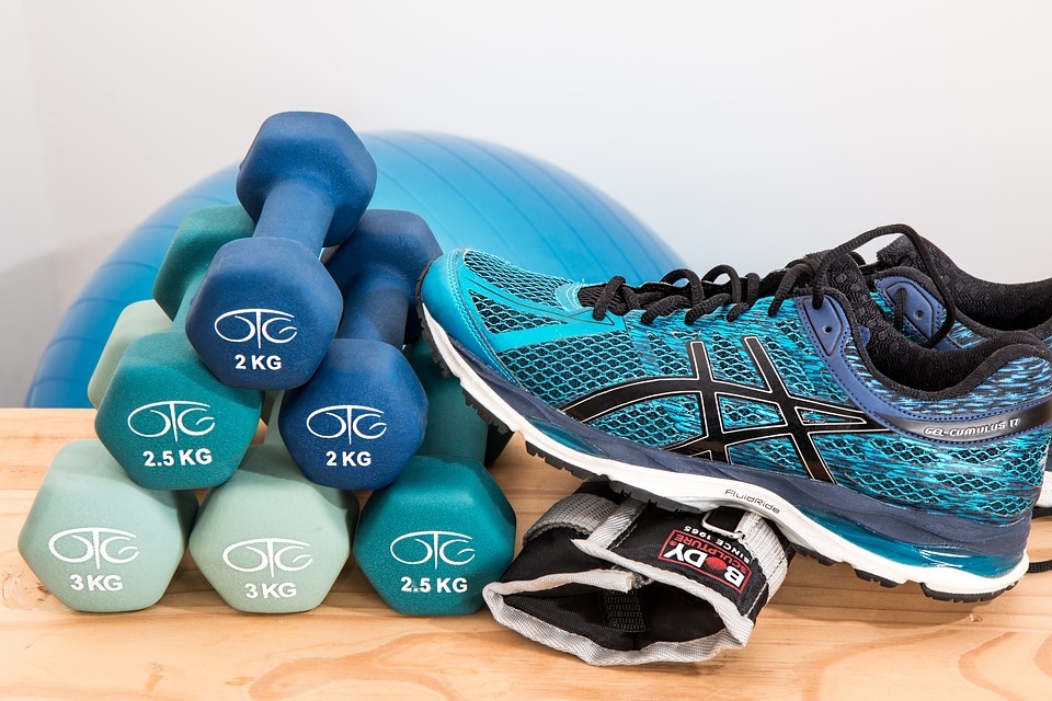 Tennis shoes, dumbbells, and a balance ball for exercising