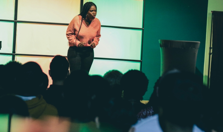 woman standing on stage speaking