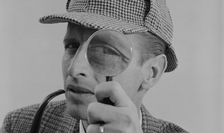 Sherlock Holmes with magnifying glass and deerstalker hat